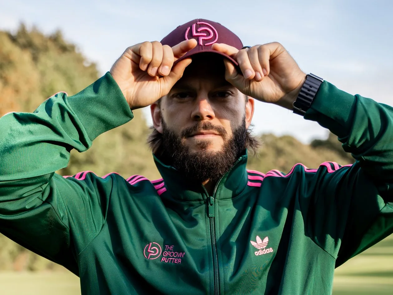 Golfer in grüner LP-Trainingsjacke setzt eine Cap auf