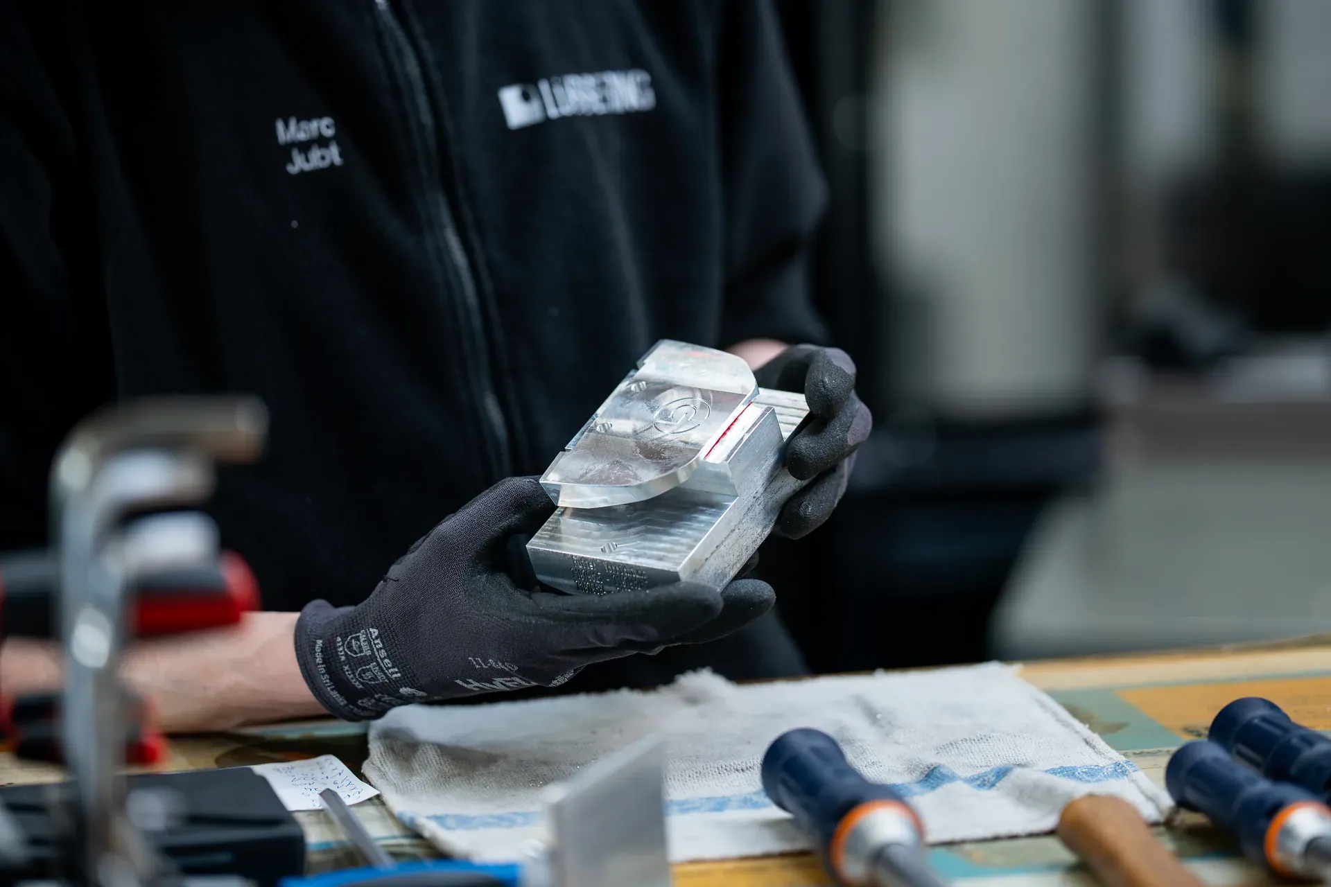 Mitarbeiter prüft einen Putterkopf-Rohling aus Stahl