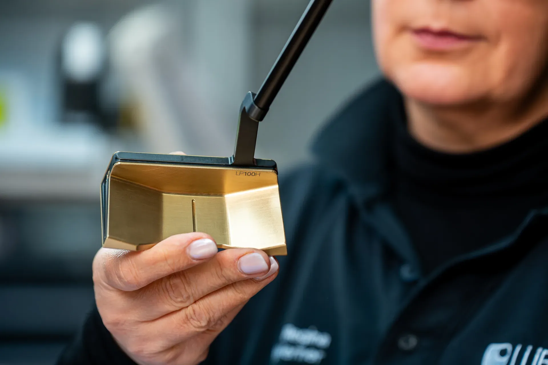 Fertiger goldener Putterkopf in den Händen einer Mitarbeiterin